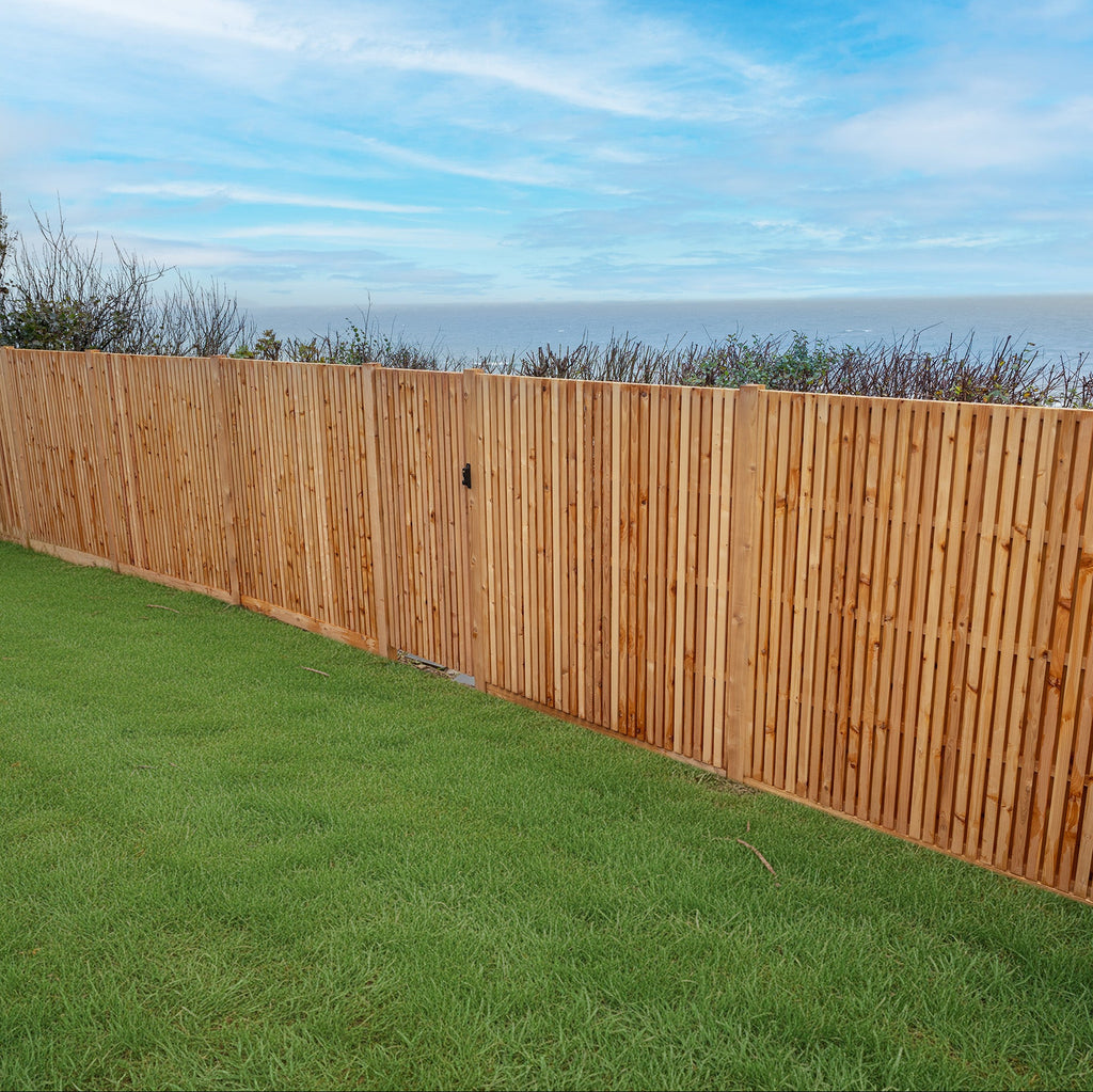 Lifestyle image of Double Sided Cedar Slatted Panels, installed in a garden 