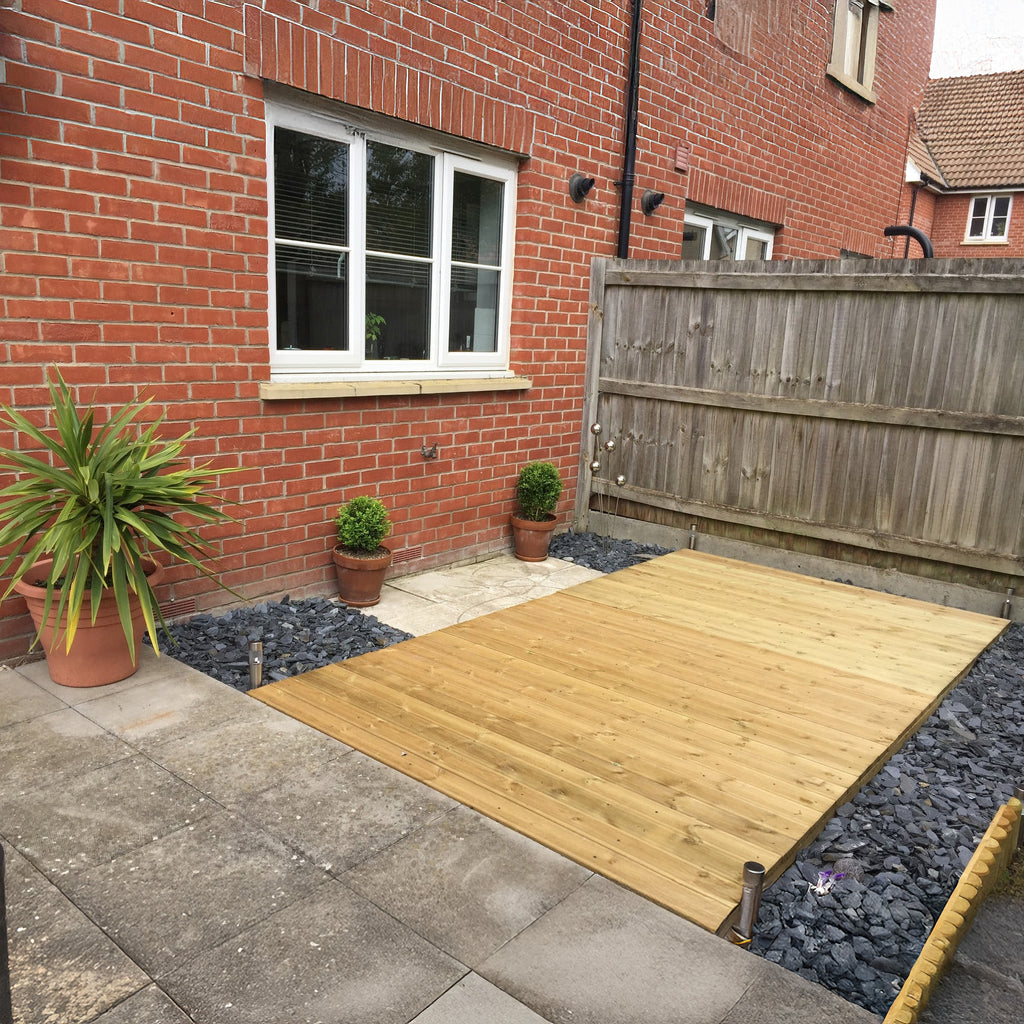 Completed wooden decking installation in garden setting 