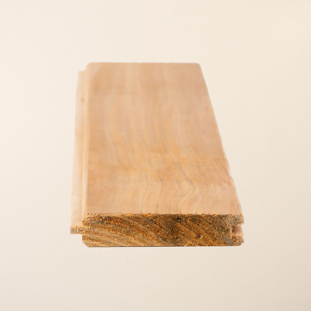 British Cedar tongue and groove boards measuring 95mm x 19mm (4" x 1"), displaying the rich reddish-brown color, smooth planed finish, and precision-milled profile that provides 83mm face coverage when installed 