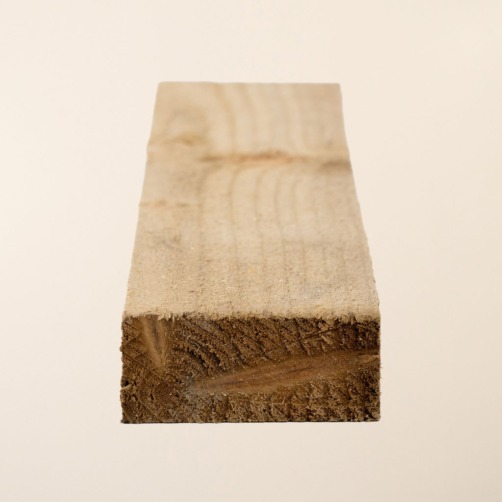 Green tanalith pressure treated fence rails measuring 38mm x 88mm, showing rough sawn finish and consistent treatment color, ideal for sturdy fence construction 